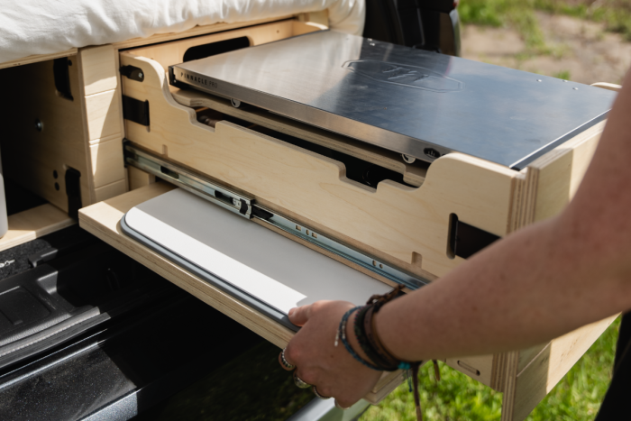 Slide-out sink and work surface in the Roadloft SUV camper kit for a functional and space-saving kitchen setup.