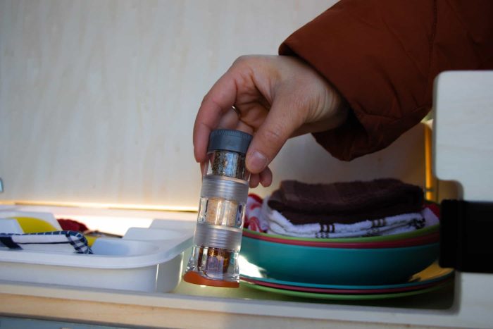 Spice rack for outdoor cooking in the Roadloft camper kit, keeping spices organized and accessible.